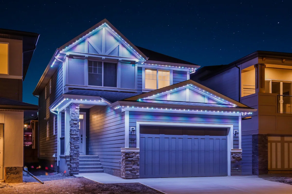 A house is beautifully illuminated with colorful lights against a night sky
